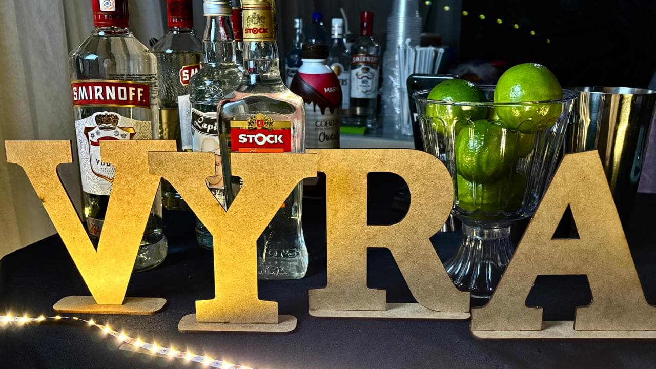 Bar Vyra Drinks preparado para um evento premium, com taças e iluminação dourada